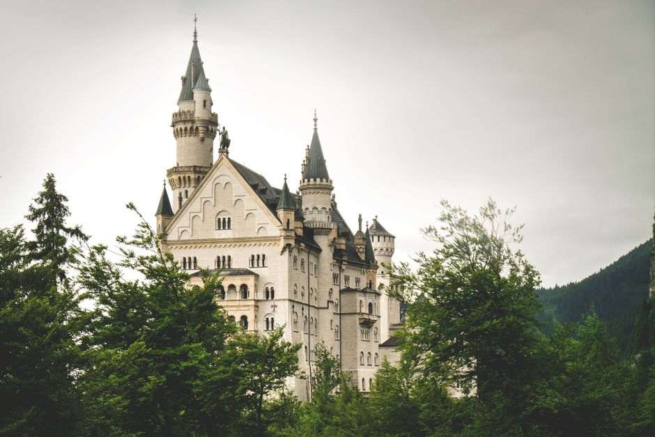 Gothic Neuschwanstein Castle in Schwangau, Bavaria, surrounded by lush greenery and historic charm.