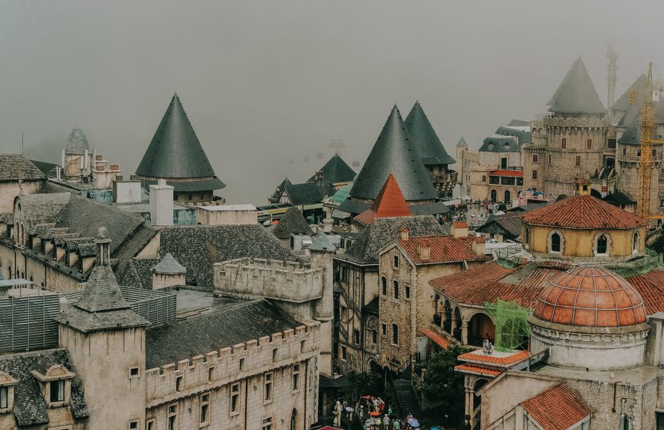 Scenic view of a medieval-style town with fog and turrets, creating a mysterious atmosphere.